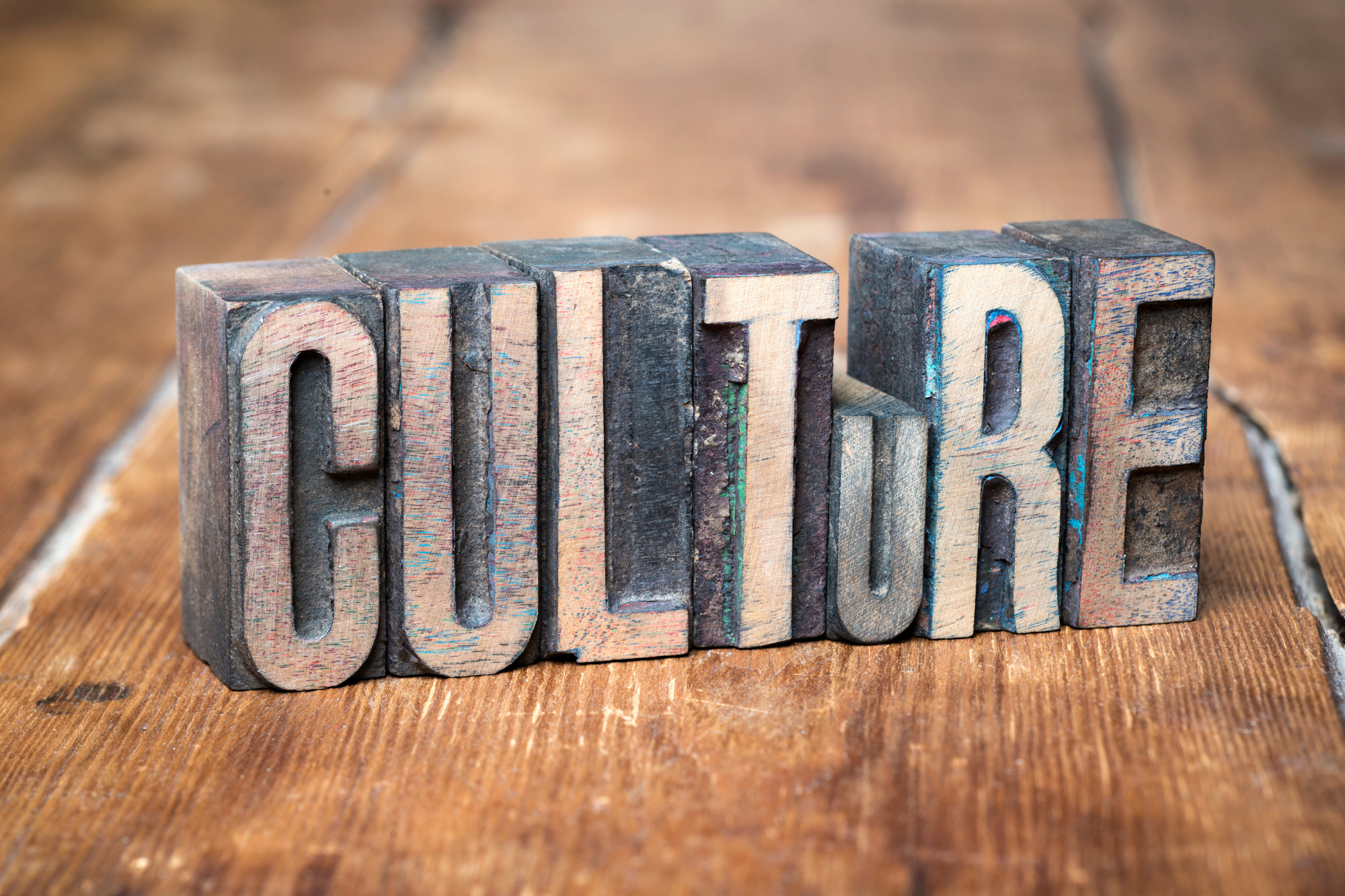 Le mot CULTURE composé de lettres en bois sur une table.